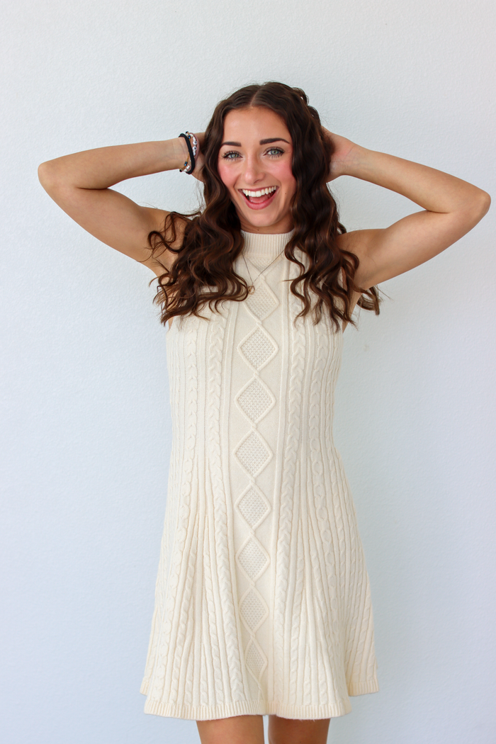 Woman wearing a knit white sweater dress