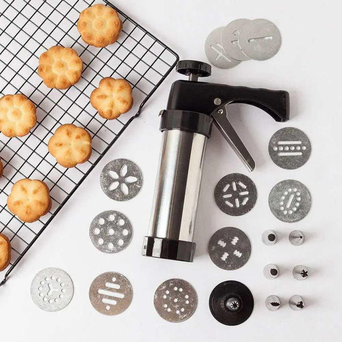 A 22cm cookie press biscuit gun machine displayed alongside 13 interchangeable pattern discs and 8 stainless piping nozzles