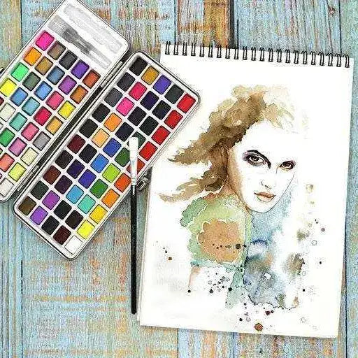 Compact watercolor paint tin showing colorful paint pans and built-in mixing palette